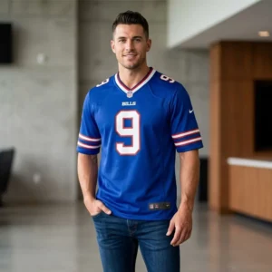 Male model wearing a royal blue Buffalo Bills jersey with the number 9 in a modern interior setting.