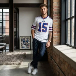 A young man wearing a white Greg Rousseau Buffalo Bills jersey in a modern loft setting.