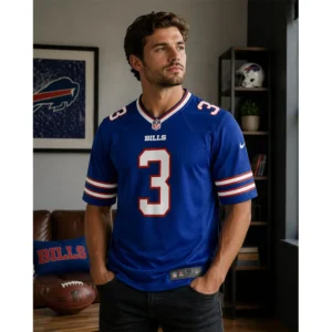 A man wearing the royal blue Buffalo Bills Damar Hamlin jersey in a home setting with Bills memorabilia and a football in the background.